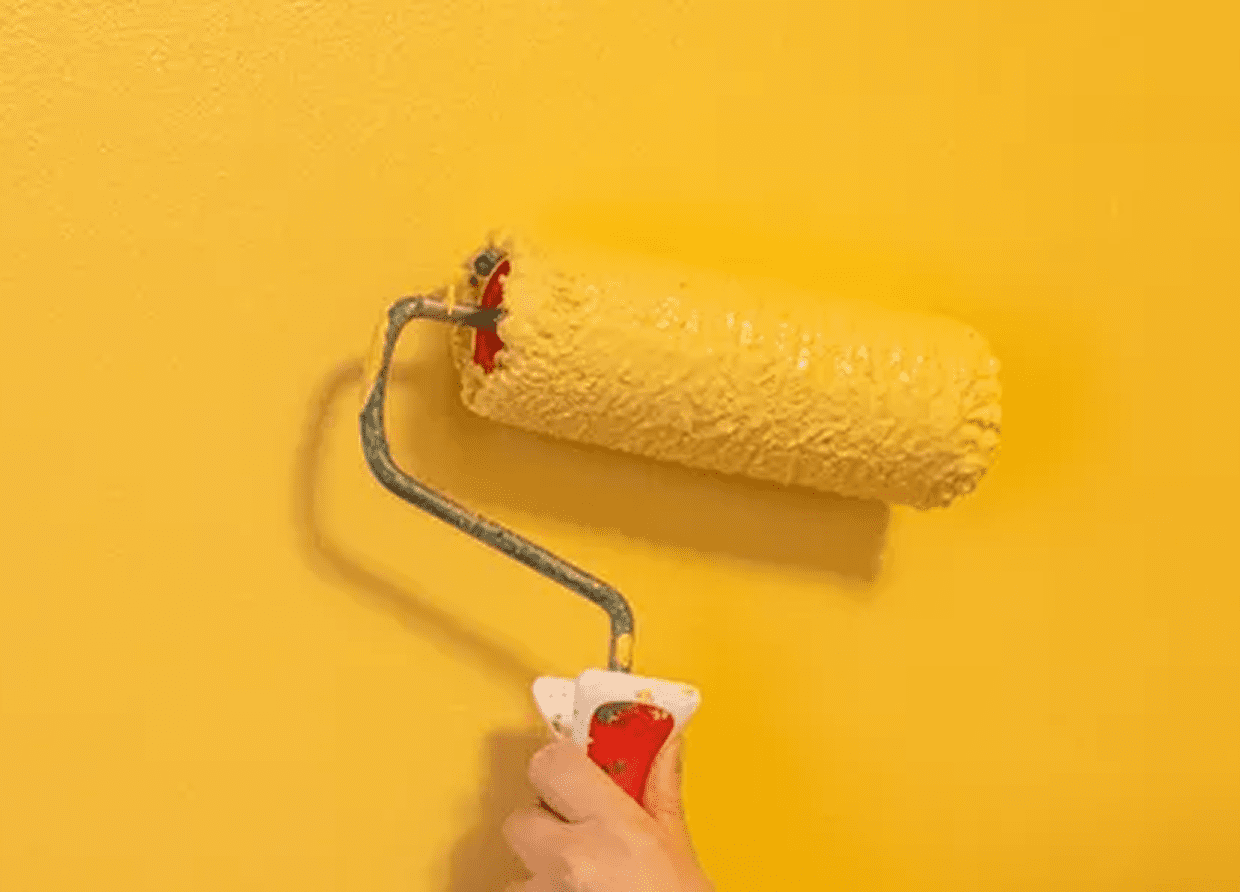Hand using paint roller on wall