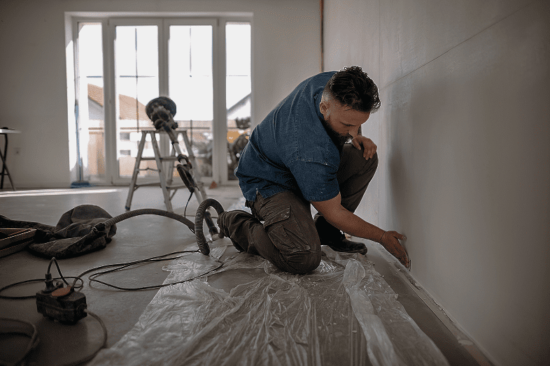 Worker applying paint in room