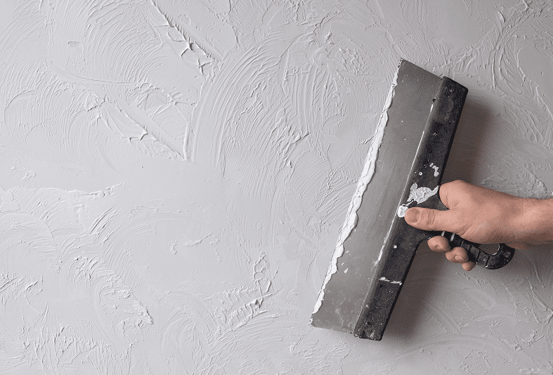 Wall plastering with a metal trowel